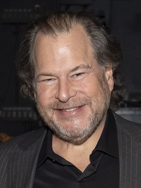 Marc Benioff, chair and chief executive of Salesforce, smiling in a dark pinstriped jacket over an open-collar dark shirt, in an official United States government portrait taken in September 2024.